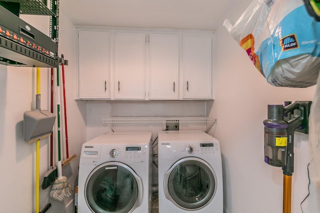 laundry room with washer and dryer and cabinets