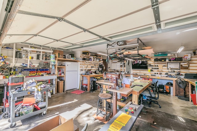 garage featuring a workshop area and white fridge