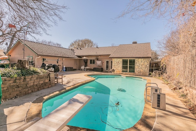 view of swimming pool featuring a diving board and a patio area