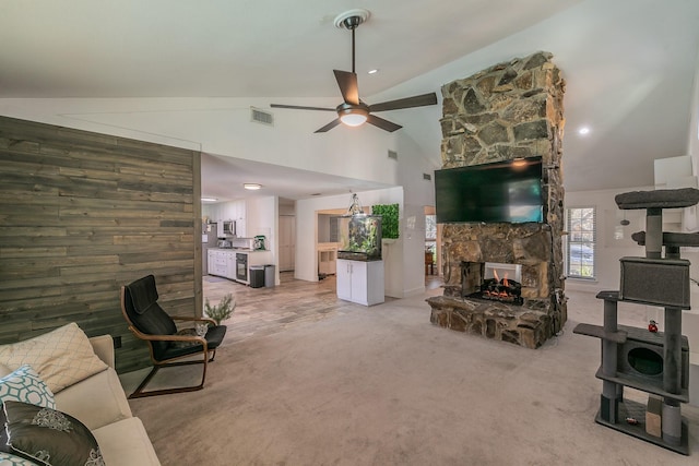 living room featuring carpet flooring, vaulted ceiling, ceiling fan, a fireplace, and wood walls