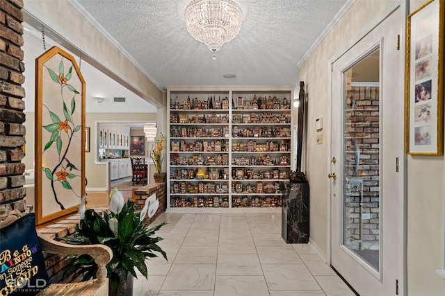 wine cellar with a notable chandelier, ornamental molding, and a textured ceiling