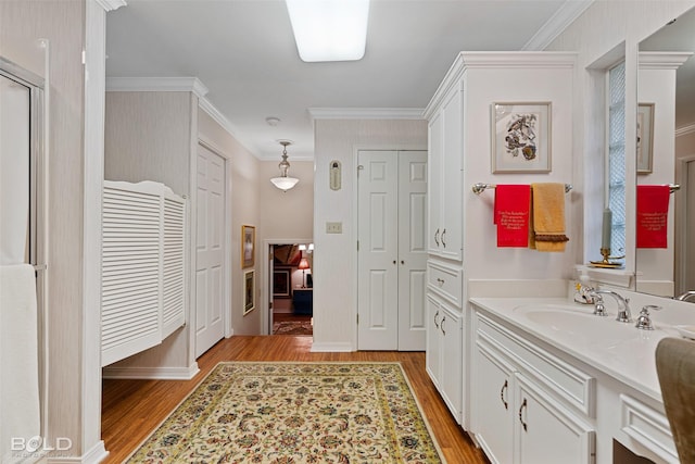 bathroom with ornamental molding, vanity, and wood-type flooring