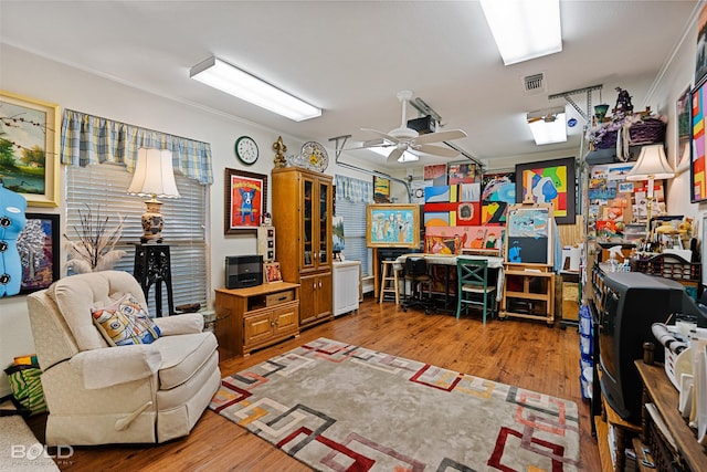 home office with wood-type flooring and ceiling fan