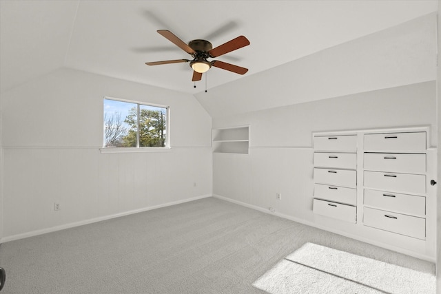 additional living space featuring ceiling fan, built in features, lofted ceiling, and light carpet