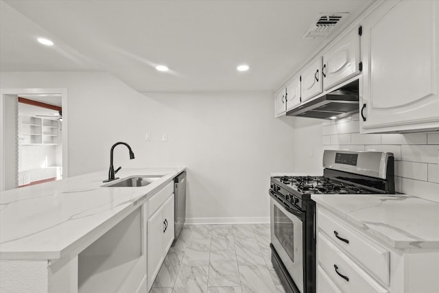 kitchen featuring sink, appliances with stainless steel finishes, white cabinetry, light stone countertops, and decorative backsplash