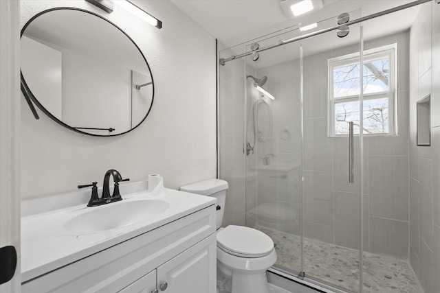 bathroom with an enclosed shower, vanity, and toilet