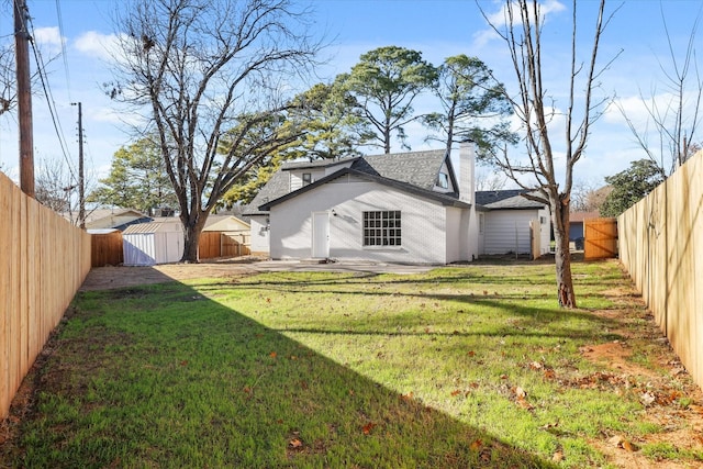 rear view of property featuring a storage shed, a yard, and a patio area