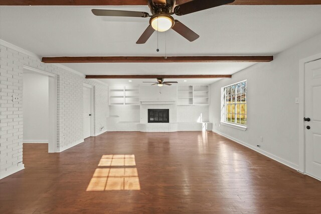 unfurnished living room with ceiling fan, brick wall, dark hardwood / wood-style floors, and a brick fireplace