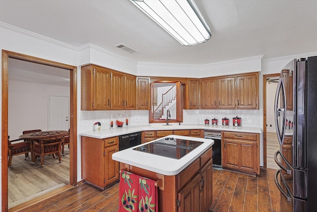 2735 Steamboat Cir, Arlington, TX 76006 - kitchen featuring black appliances, brown cabinetry, dark wood finished floors, and ornamental molding