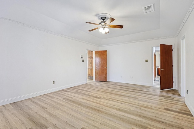 empty room featuring a raised ceiling, ceiling fan, and light hardwood / wood-style floors