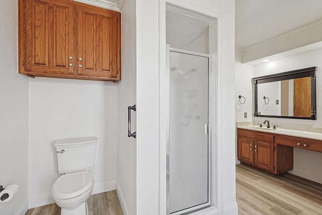 bathroom with an enclosed shower, hardwood / wood-style floors, vanity, and toilet