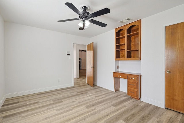 interior space featuring built in desk, ceiling fan, and light hardwood / wood-style flooring