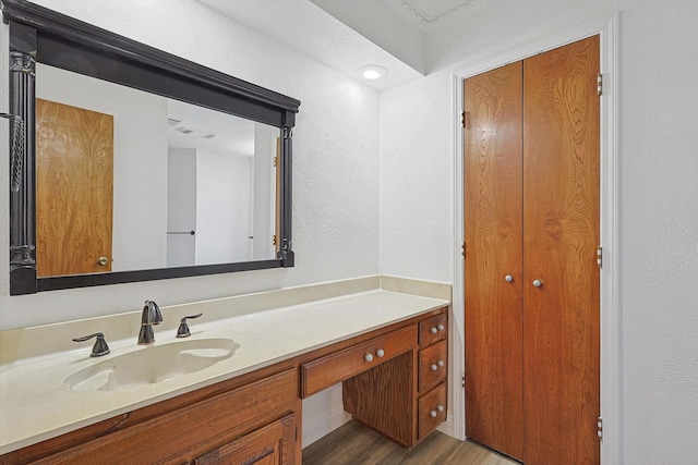 2735 Steamboat Cir, Arlington, TX 76006 - bathroom featuring vanity, wood finished floors, a textured wall, and a closet