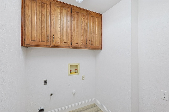 washroom with electric dryer hookup, hookup for a washing machine, cabinets, wood-type flooring, and hookup for a gas dryer