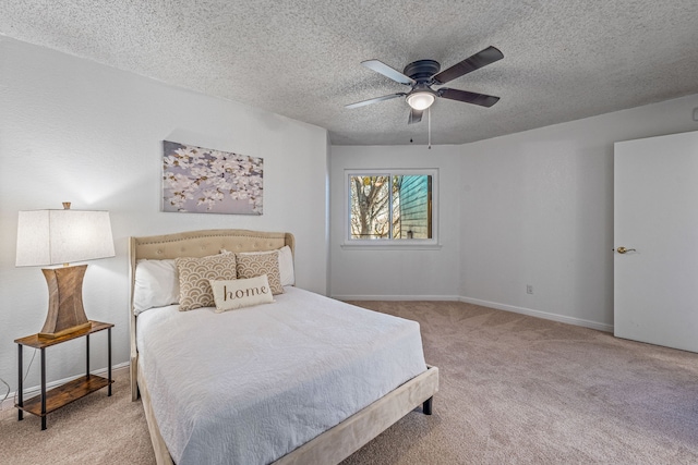 carpeted bedroom featuring ceiling fan and a textured ceiling