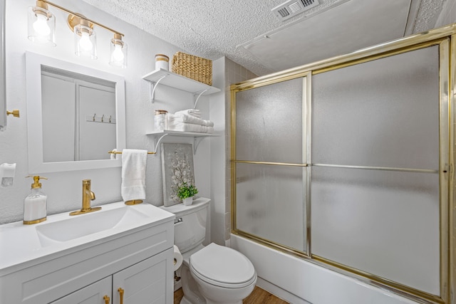 full bathroom with shower / bath combination with glass door, vanity, toilet, and a textured ceiling