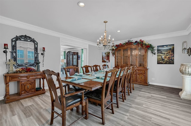 dining space featuring ornamental molding, a chandelier, and light wood-type flooring