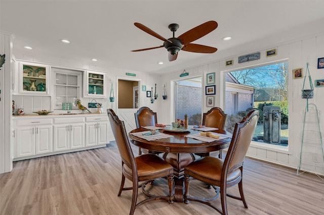 dining space with ceiling fan and light hardwood / wood-style flooring