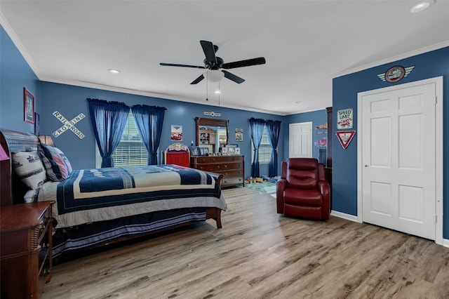 bedroom featuring crown molding, wood-type flooring, a closet, and ceiling fan