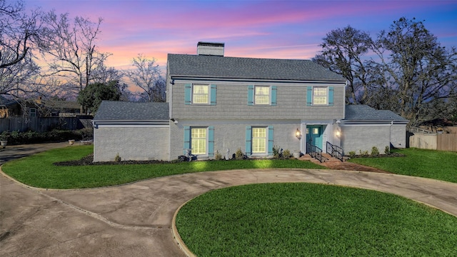 colonial-style house featuring a lawn