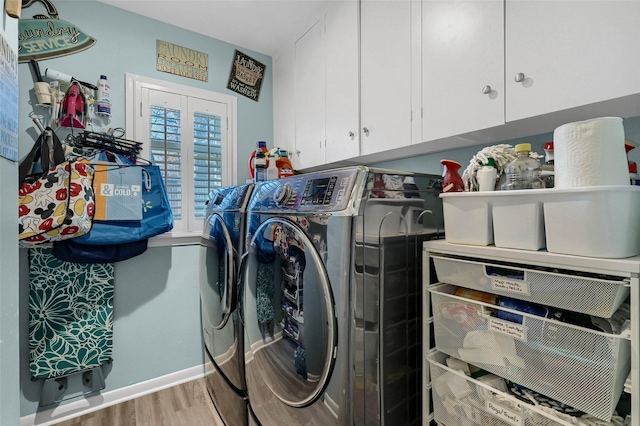 laundry room featuring cabinets, independent washer and dryer, and light wood-type flooring