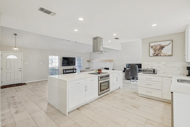 kitchen with white cabinets, oven, island range hood, and pendant lighting