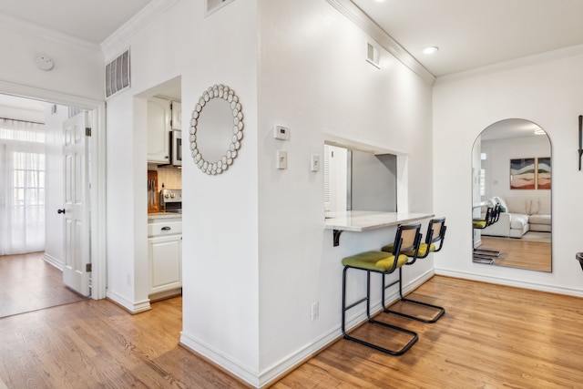 hall with light wood-type flooring and crown molding