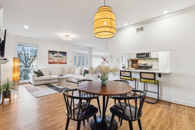 dining room featuring light hardwood / wood-style floors and ornamental molding