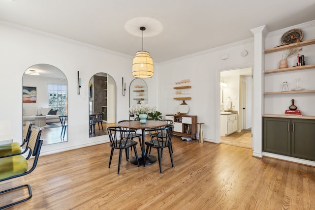 dining space featuring ornamental molding and light wood-type flooring