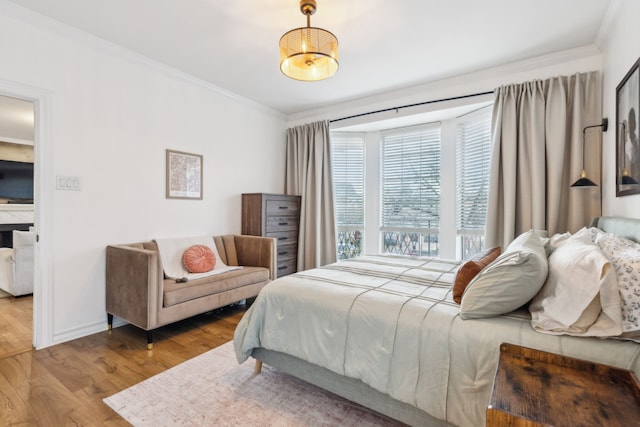 bedroom featuring light wood-type flooring and crown molding