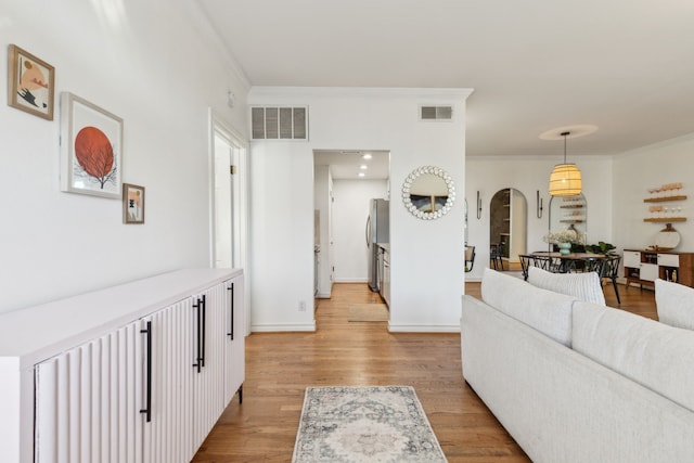 living room featuring ornamental molding and light hardwood / wood-style flooring