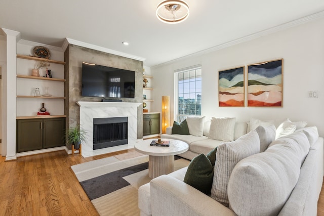 living room with a premium fireplace, crown molding, and light hardwood / wood-style flooring