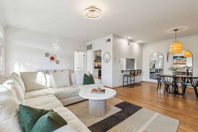 living room with hardwood / wood-style floors and ornamental molding