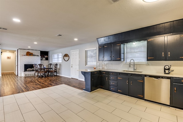 kitchen featuring decorative backsplash, sink, stainless steel dishwasher, and plenty of natural light