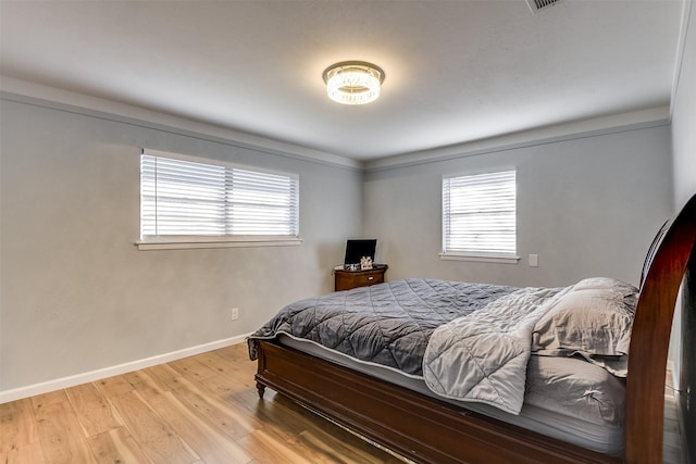 bedroom featuring multiple windows and light wood-type flooring