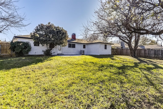 rear view of house with a lawn and central AC