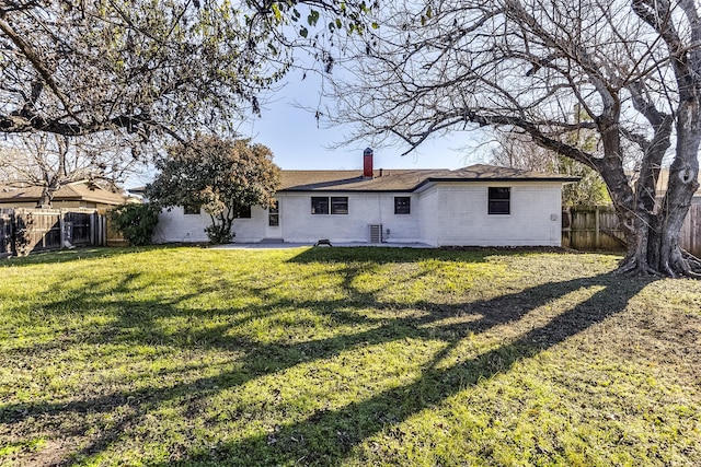 rear view of property featuring a lawn