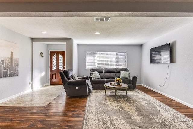 living room with dark hardwood / wood-style flooring and a textured ceiling