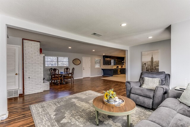 living room featuring a textured ceiling and dark wood-type flooring