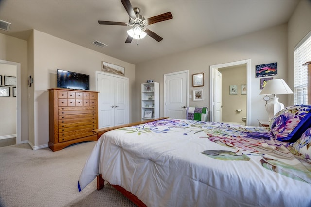 carpeted bedroom with ceiling fan and ensuite bath