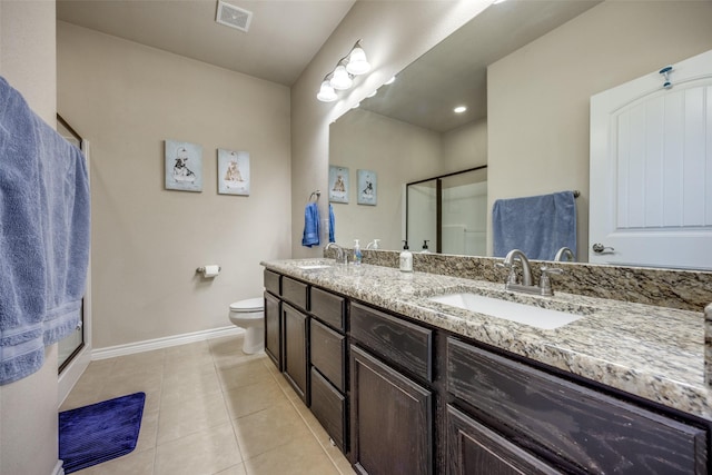 bathroom with toilet, tile patterned floors, vanity, and a shower with shower door