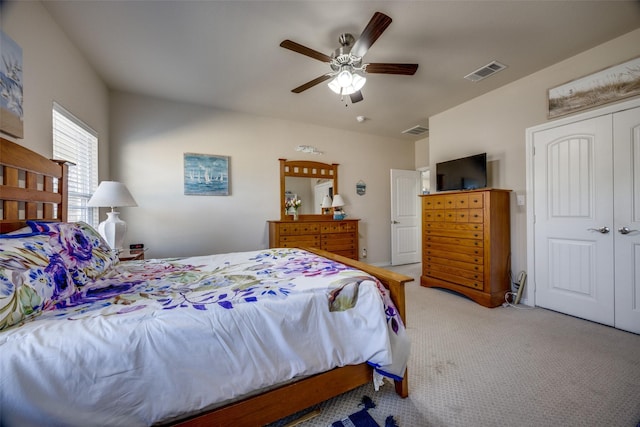 bedroom with ceiling fan, a closet, and light carpet