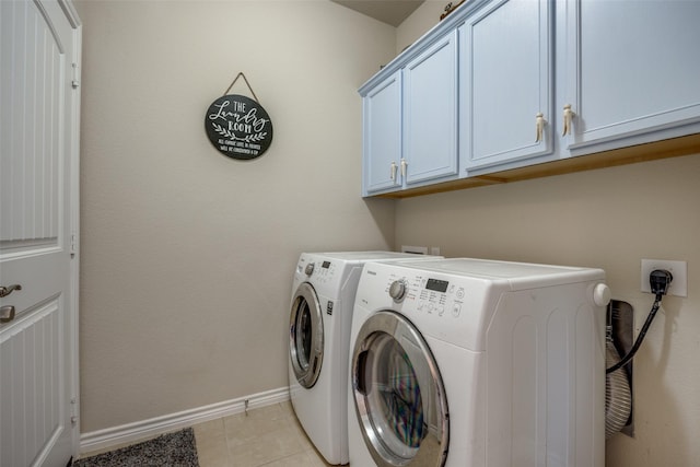 clothes washing area with washer and clothes dryer, light tile patterned flooring, and cabinets