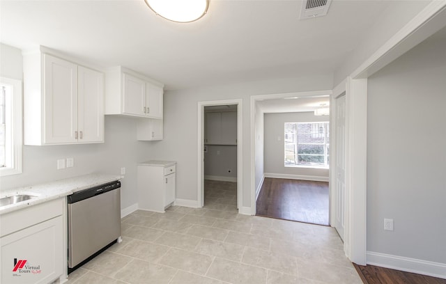 kitchen with white cabinetry, dishwasher, light stone countertops, and sink