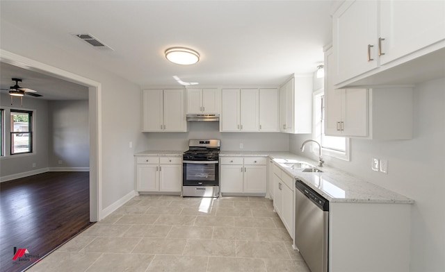 kitchen featuring appliances with stainless steel finishes, a wealth of natural light, sink, and white cabinets