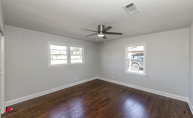 empty room featuring ceiling fan, a textured ceiling, and dark hardwood / wood-style flooring