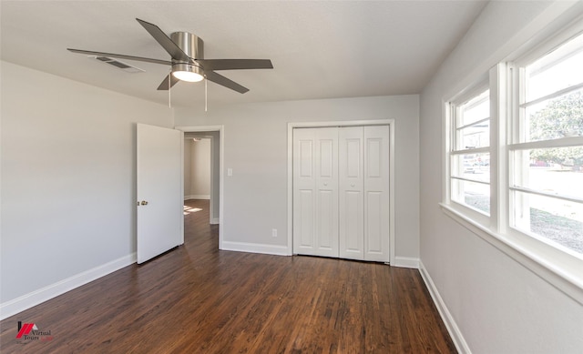 unfurnished bedroom with dark hardwood / wood-style flooring, a closet, and ceiling fan