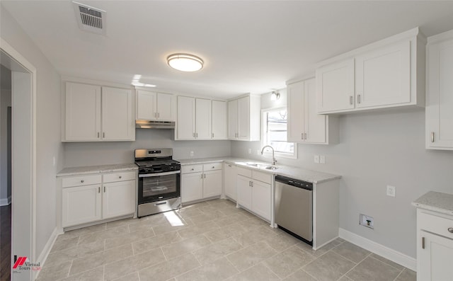 kitchen featuring white cabinetry, stainless steel appliances, light stone countertops, and sink