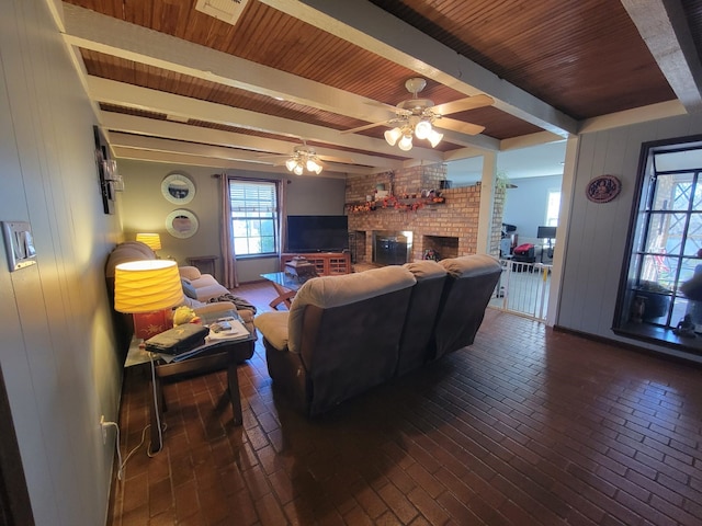 living room featuring a brick fireplace, ceiling fan, beam ceiling, wooden ceiling, and wood walls