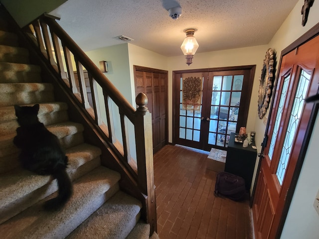 entryway featuring french doors and a textured ceiling